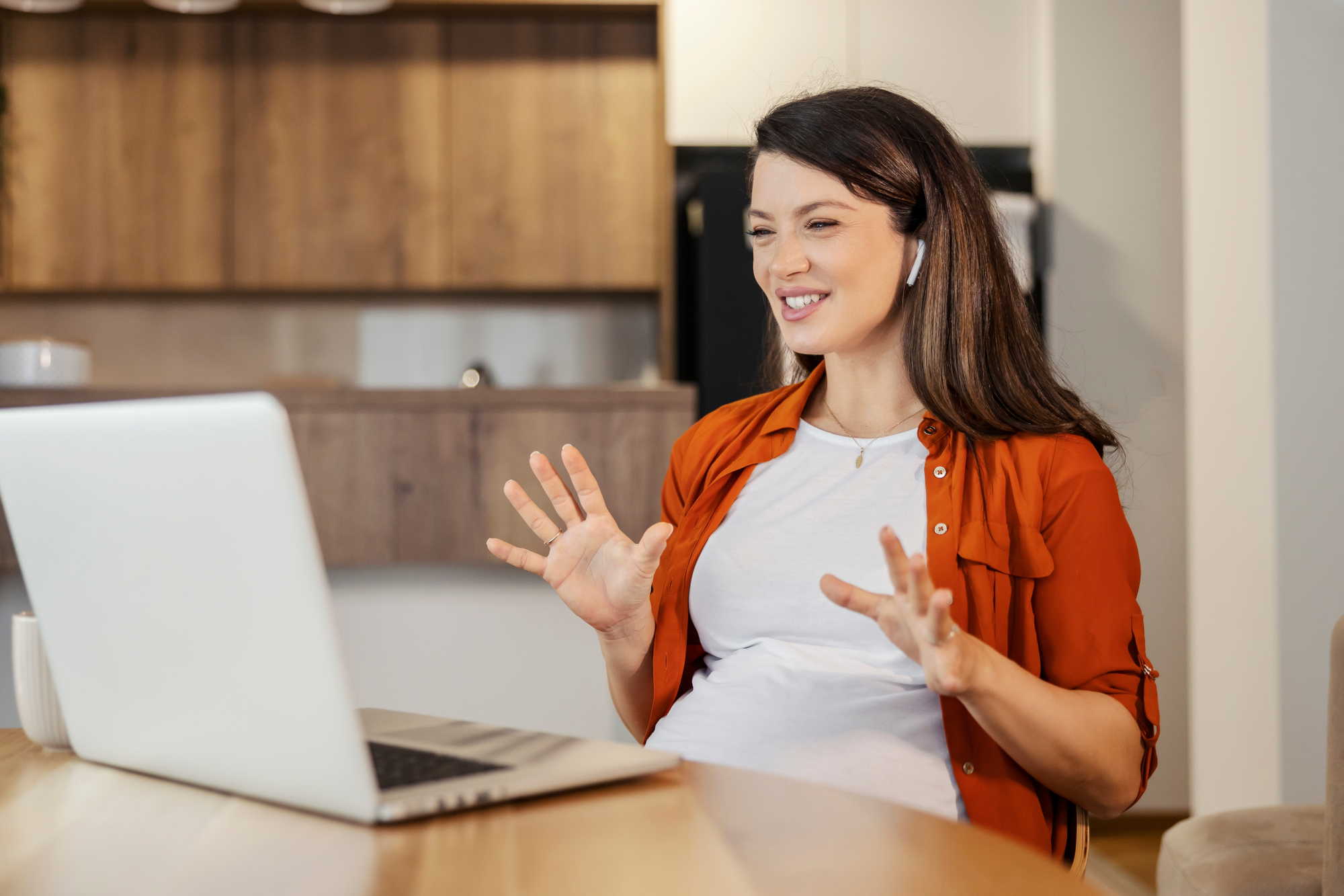 Picture of pregnant woman talking on a virtual meeting with a laptop
